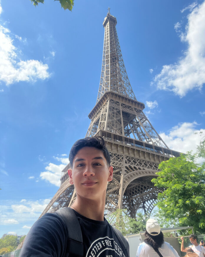 Estudante de jornalismo em frente a Torre Eiffel para cobertura das Olimpíadas